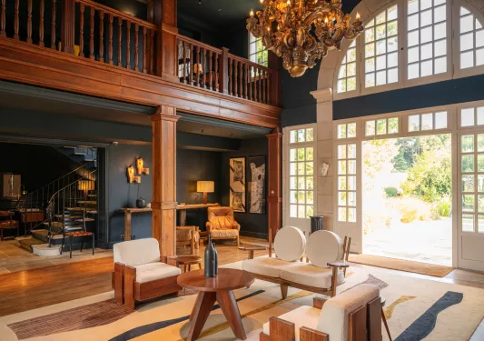 Indoor, wooden cottage style lobby with large open doors to the right