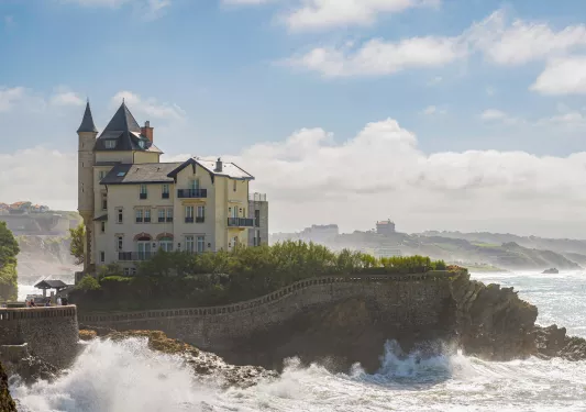 House on a cliff surrounded by waves