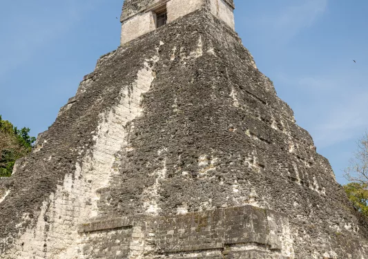 Father and two sons looking up at an ancient pyramid