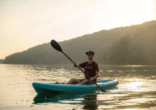 Man on kayak in the middle of a lake