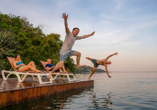 Two men jumping off a port into the ocean