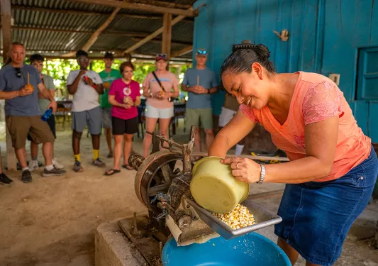 Woman milling corn in a machine
