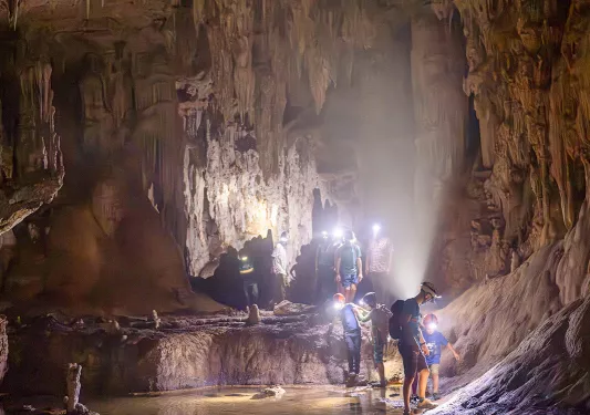 Group of guests exploring a wet cave