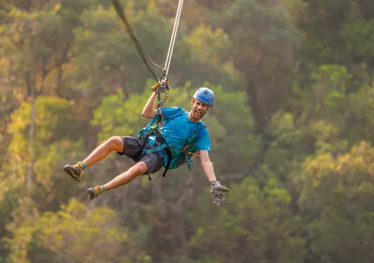 Man ziplining in the middle of the forest