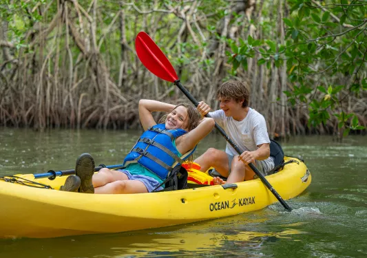 Two children kayaking in a river