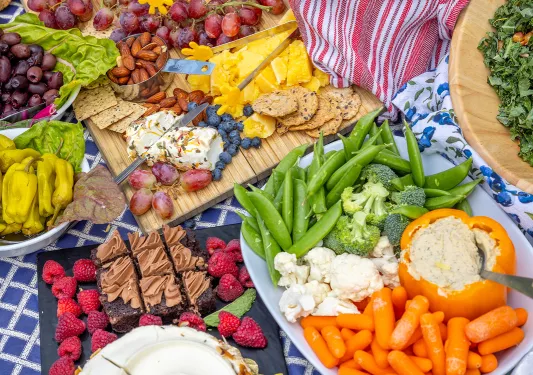 Table full of charcuterie boards, fruits, vegetables, and snacks