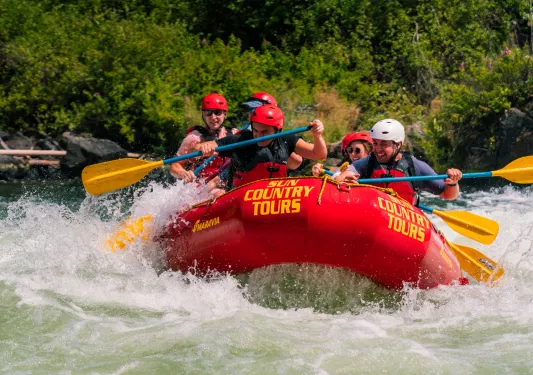Group of people on a red rafting, paddling through a river
