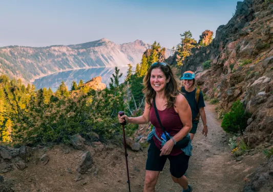 Two women smiling while ascending a dirt trail