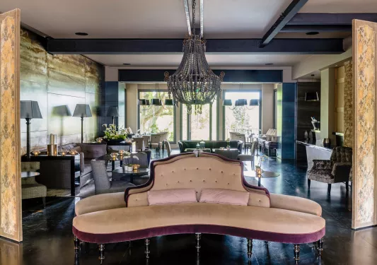 Indoor lounge with a large chandelier and cushioned sofas 