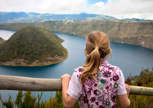Child looking over a railing at an island