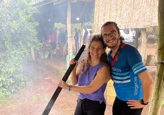 Two people stir a large pot