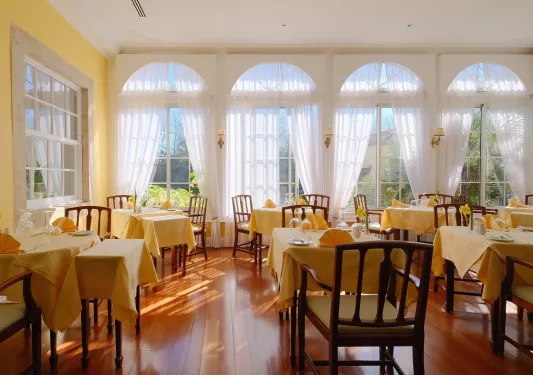 Indoor dining hall with yellow tables and wooden chairs
