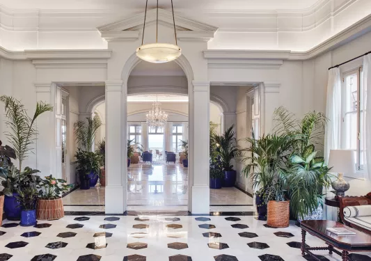 Lobby with granite floors and plants in vases by the corners of the room