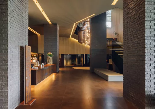 Hotel lobby with exposed stone and a stairway on the right