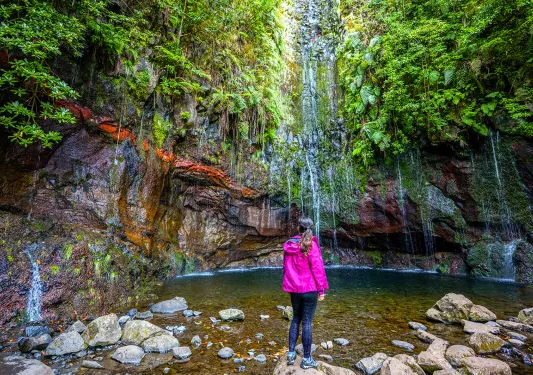 Woman standing on a rock looking at a lake 