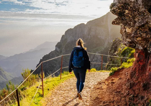 Woman walking on a stone path descending on a mountain