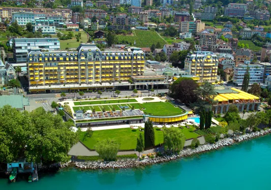 Large hotel building by the ocean's coast line and a large grass area