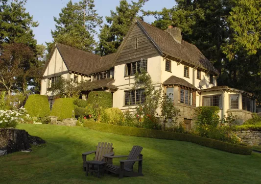Rustic building surrounded by tall bushes and a grass slope