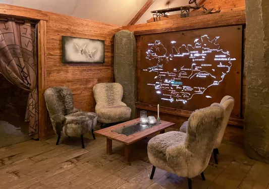 fur covered chairs around a table with a map on the wall