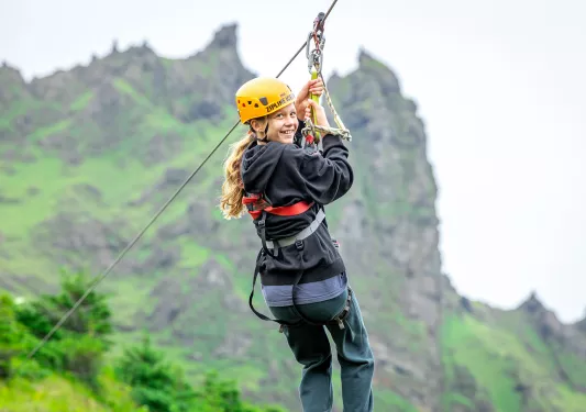 Girl smiling while riding a zipline