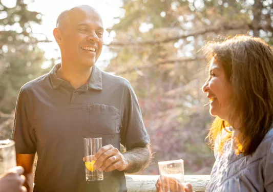 Man and woman holding glasses while smiling and laughing