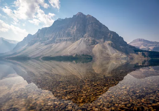 clear reflective lake next to a mountain