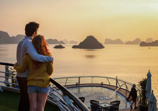 two people embracing and looking out at the sunset