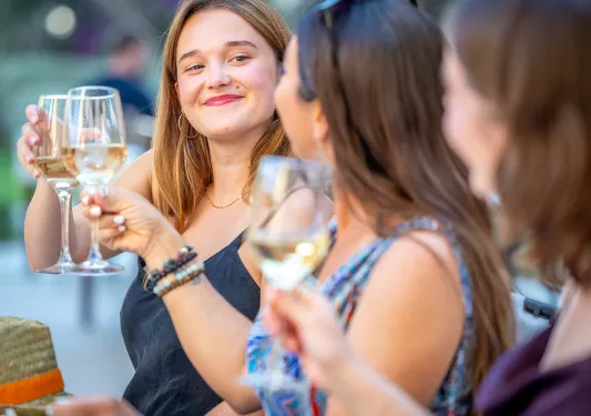 Three women smiling and raising their wine glasses