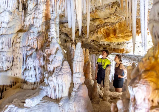 Man and woman inside of a white cave, looking up along the walls