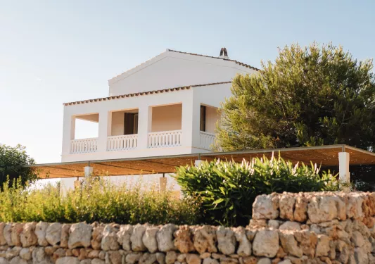 white house with porch on the hill