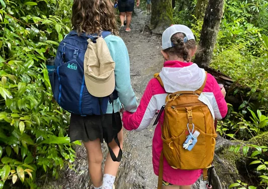 Two kids with backpacks on a hike