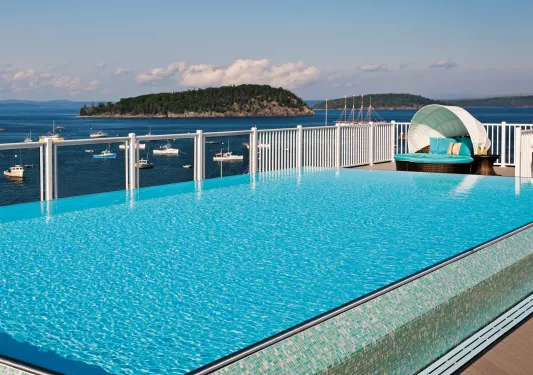 Outdoor pool overlooking the ocean, filled with boats