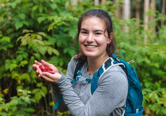 a woman poses with a handful of berries