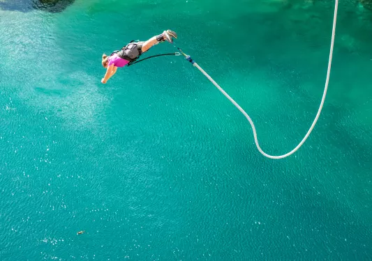 person bungee jumping into water