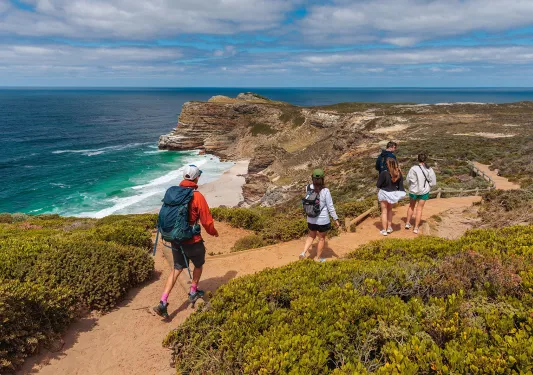People hike down a beachfront road