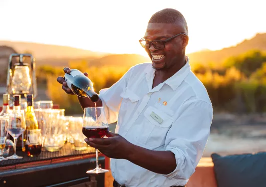 A man pours wine into a wine glass