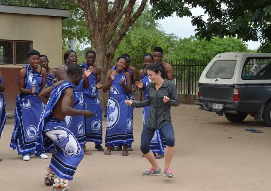 Woman danving with African tribe members