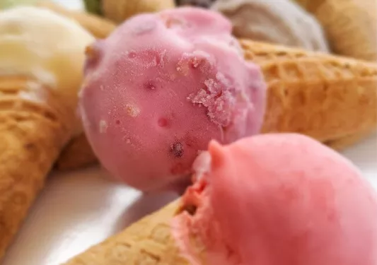 two ice cream cones topped with pink ice cream