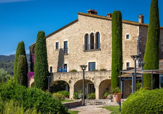 Stone house surrounded by green trees