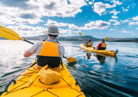 Three people kayaking in the middle of a lake