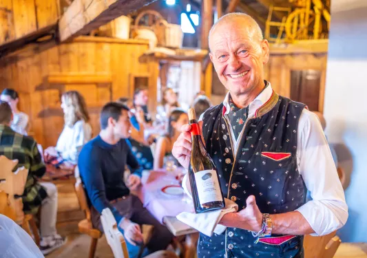 Man smiling and holding a bottle of wine