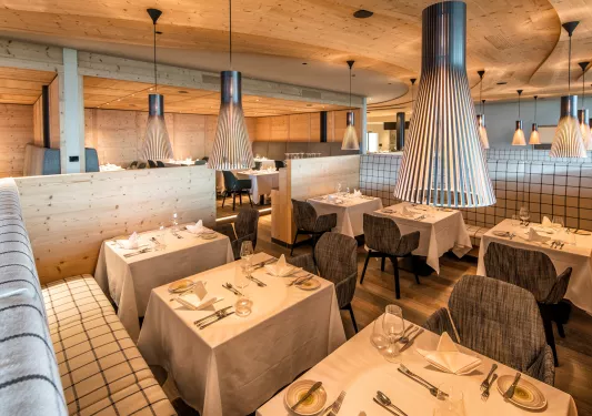 Indoor dining area with gray cushioned chairs and black light fixtures