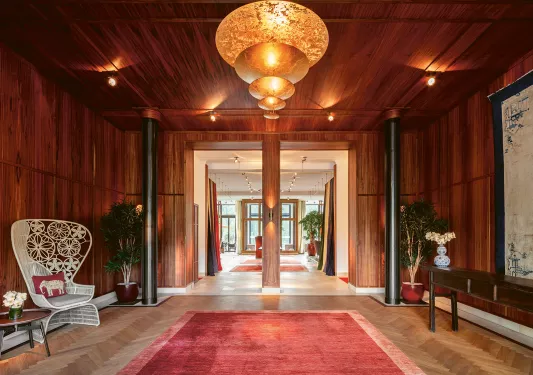 Wooden building entrance with a red carpet and black pillars