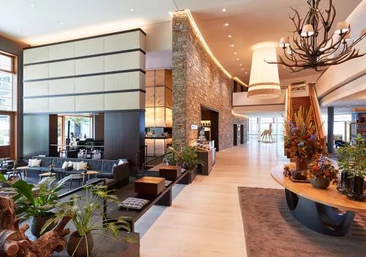 large hotel lobby with armchairs and grand staircase