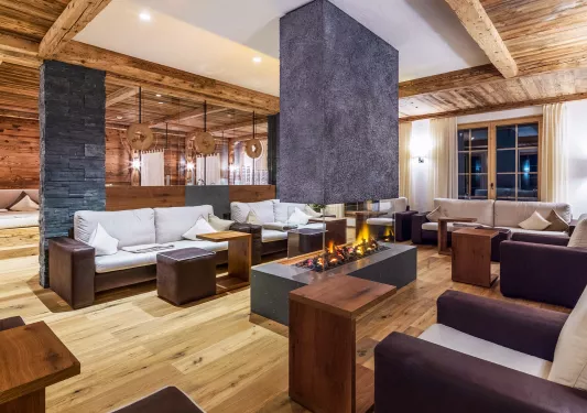Brown and white couches surrounding a fireplace in a hotel lobby