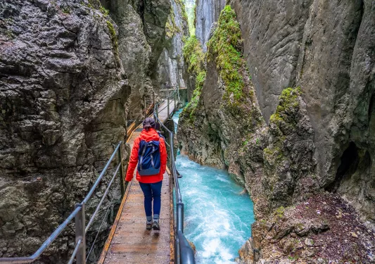 Woman walking on a bridge in between two cliffs