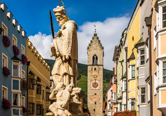 Large Spanish-style statue with a clock tower in the background