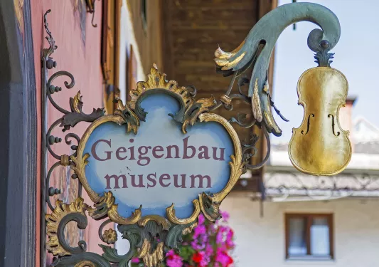 Antique Geigenbau Museum sign with a gold violin