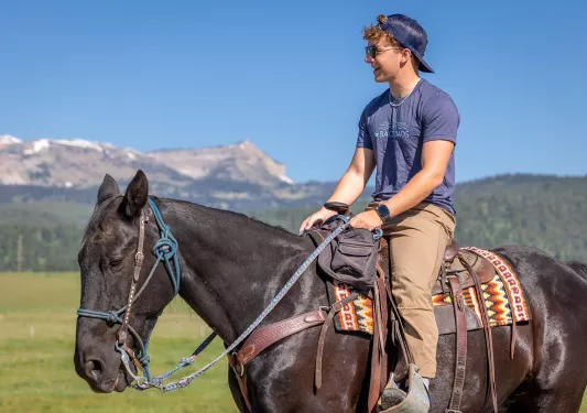 Man wearing sunglasses while riding on a horses' back