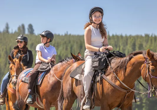 A girl smiling while horseback riding